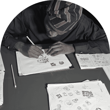 Yinka sketching logo ideas at a desk